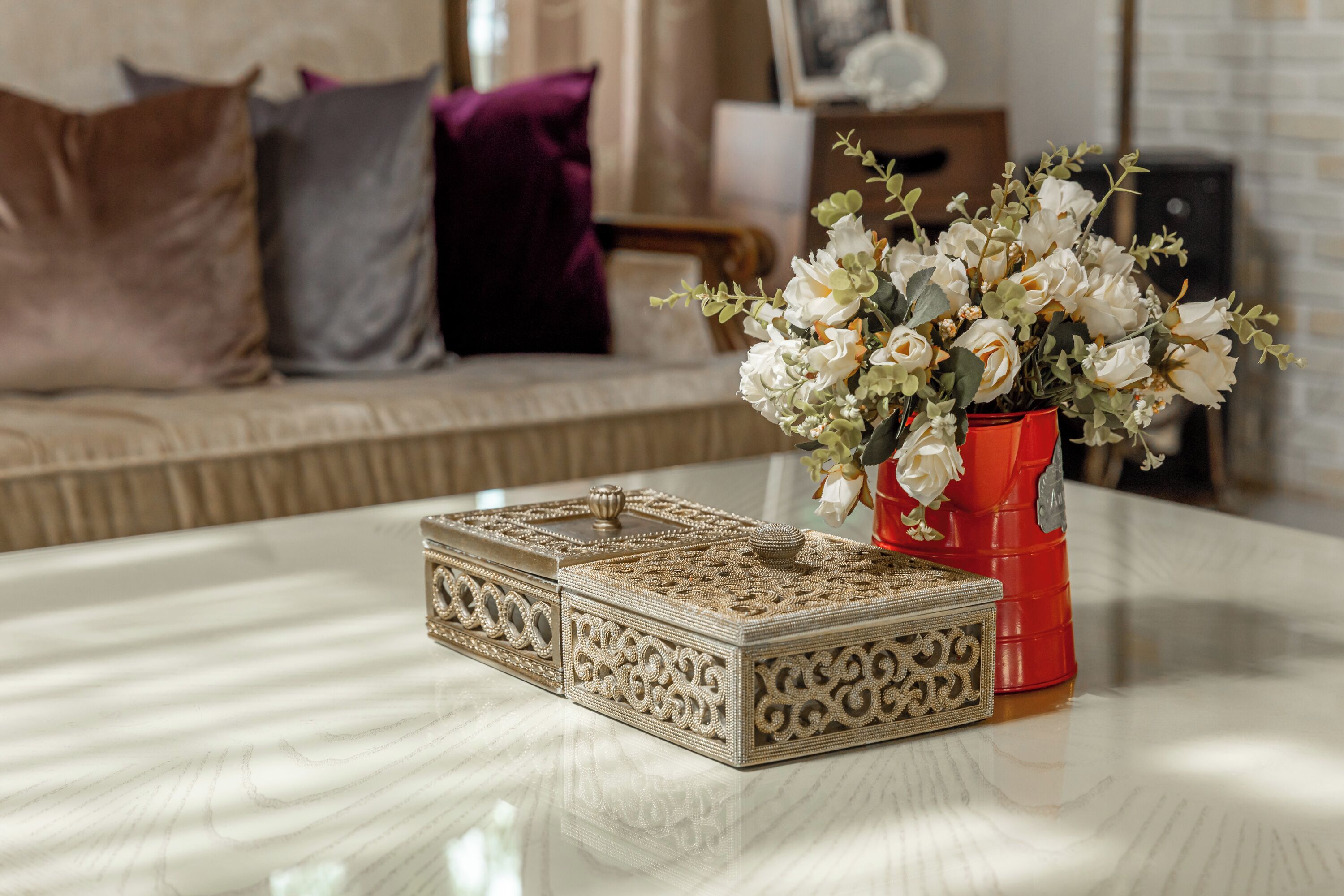 Una mesa con cajas decorativas y un jarrón de flores.
