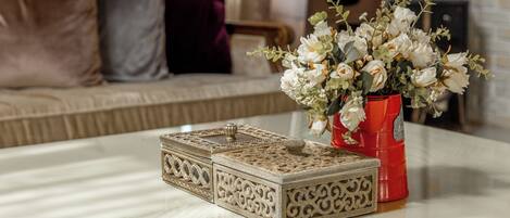 Una mesa con cajas decorativas y un jarrón de flores.