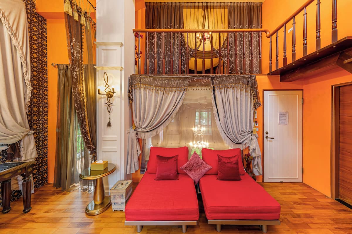 Una habitación con dos camas, un candelabro y una escalera.