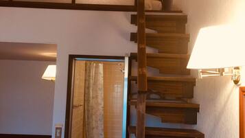 A staircase leading to a bathroom with a toilet and shower.