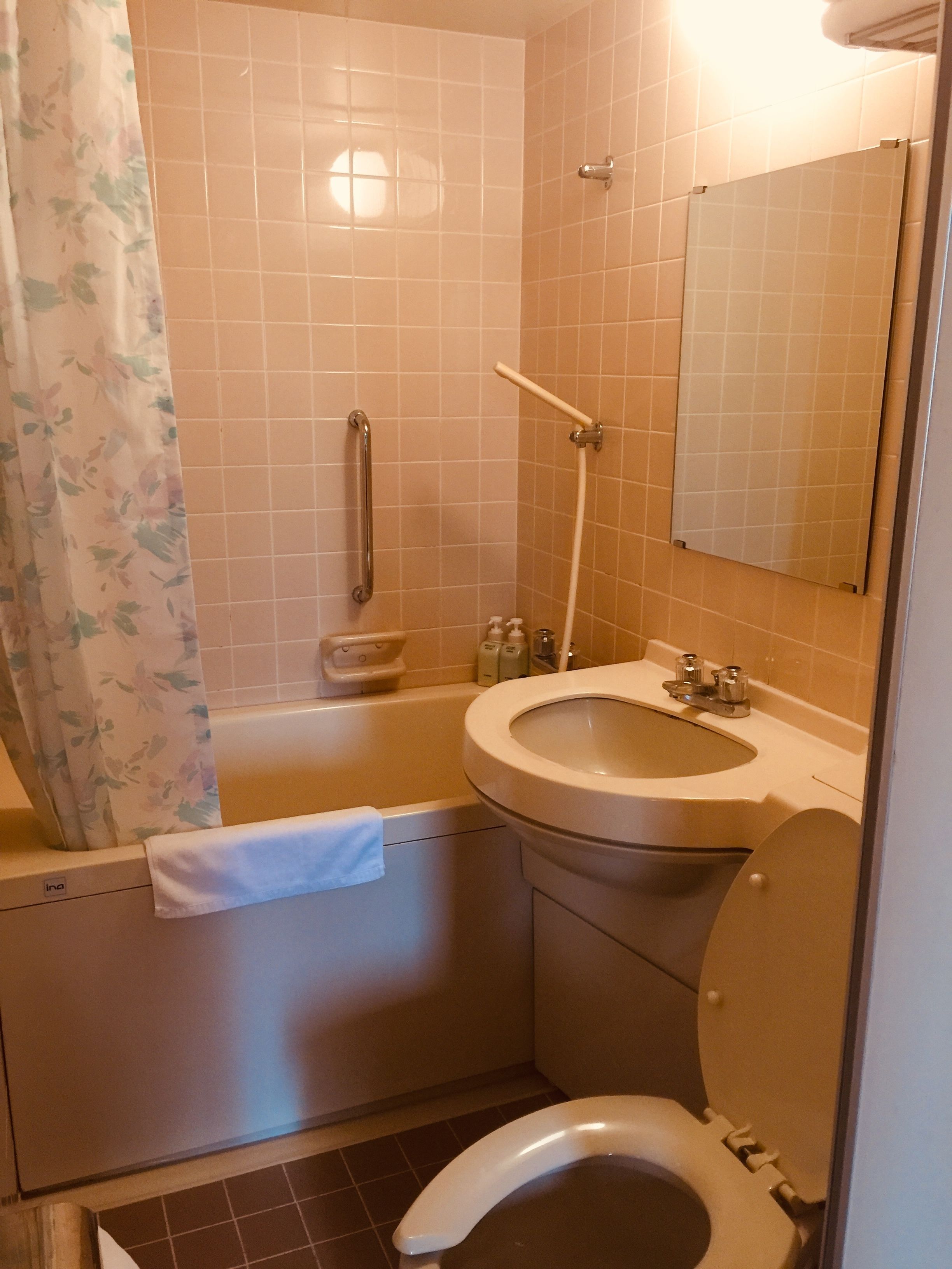 A bathroom with a bathtub, a toilet, a sink, and a mirror.