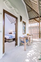 Una habitación con una cama, una mesa y una silla. Hay una ventana y una puerta.