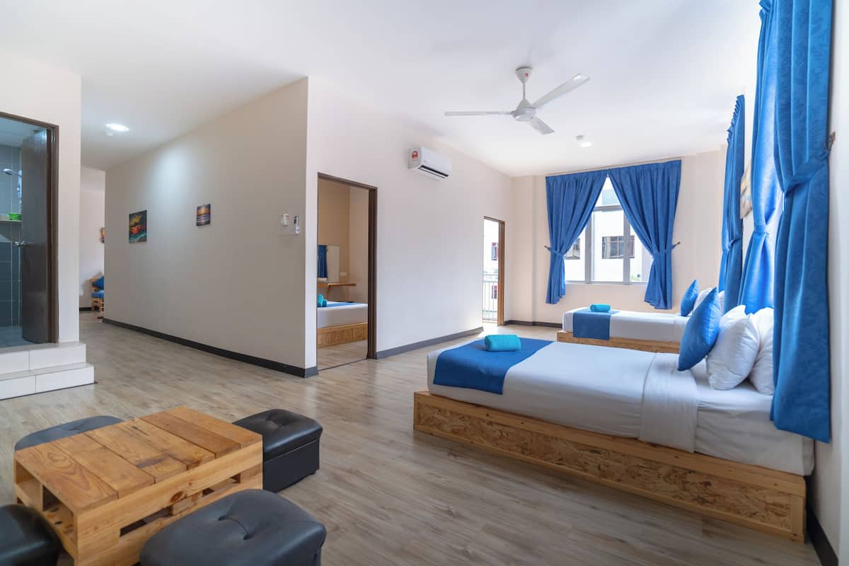 Una moderna camera d'hotel con un letto, un tavolino in legno, una ventola a soffitto e vista sull'esterno.