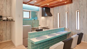 Una cocina moderna con una isla central, horno empotrado y una ventana sobre el fregadero.