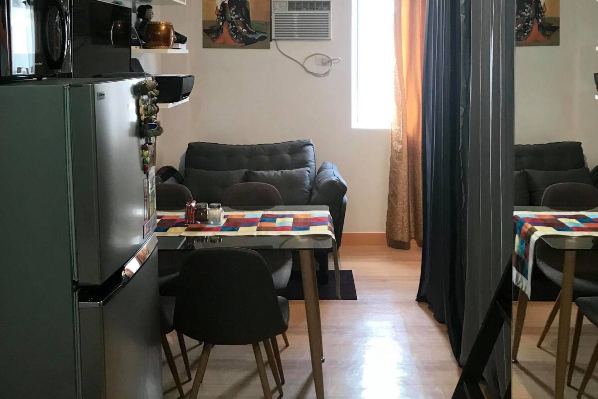 A compact living space with a kitchenette, a dining area, and a sofa.