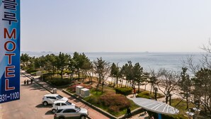 A view of a motel with a parking area, a beach, and a clear sky. - Blue Motel (Boryeong)