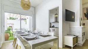 Een moderne keuken met een eethoek, een aan de muur bevestigde televisie en een open haard.