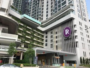 A modern hotel with a prominent 'R' logo, multiple floors, and a rooftop garden. - The Robertson 1 Bedroom Bukit Bintang KL (Kuala Lumpur)