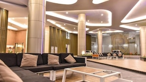A modern lobby with a sectional sofa, a coffee table, and a seating area with chairs. - The Robertson 1 Bedroom Bukit Bintang KL (Kuala Lumpur)