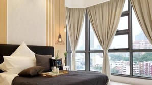 A modern bedroom with a large bed, a city view, and a bedside table with a tray. - The Robertson 1 Bedroom Bukit Bintang KL (Kuala Lumpur)