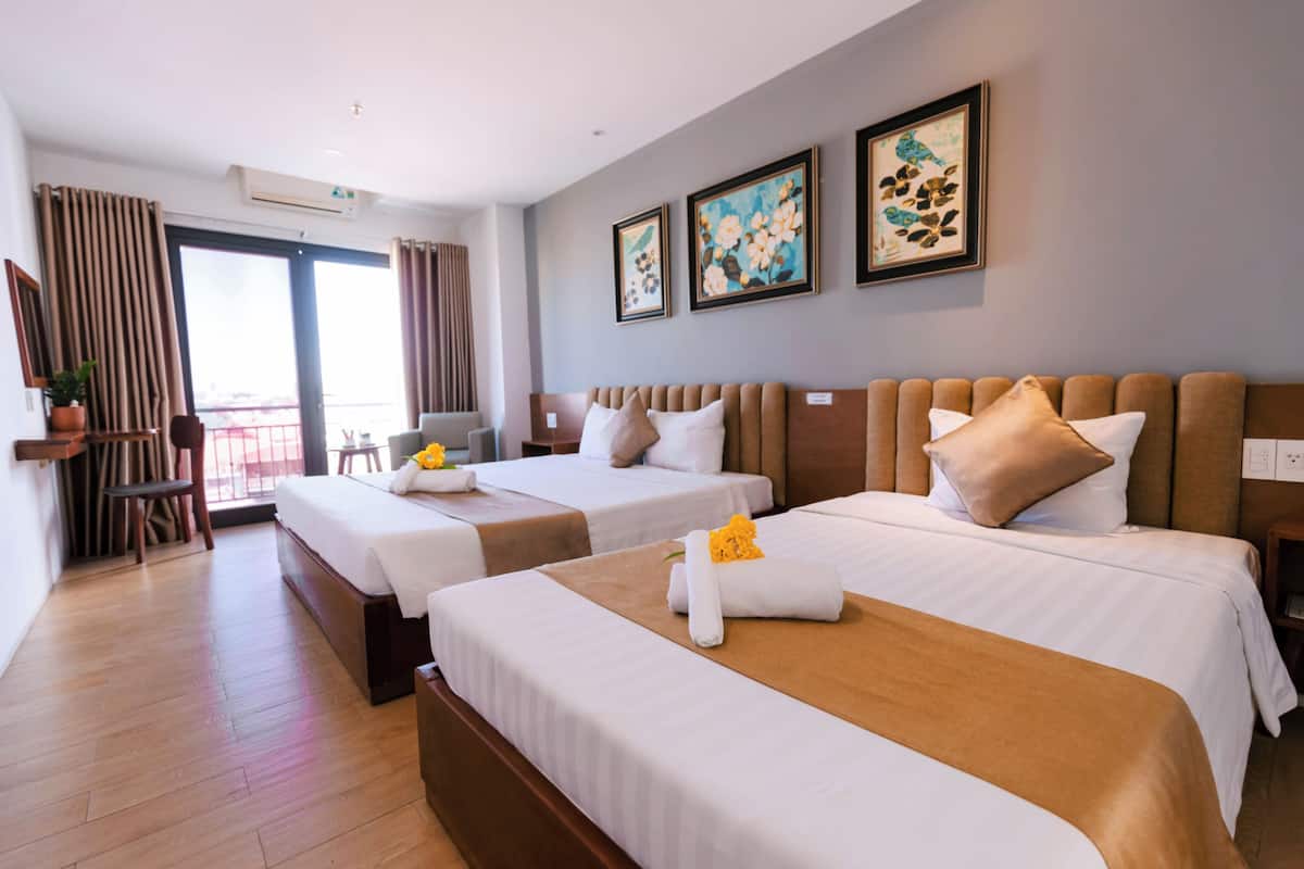 Ein Hotelzimmer mit zwei Betten, einem Balkon und Bildern an der Wand.