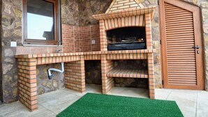 A stone wall with a brick oven, a window, and a door. - Casa da Caneleira (Camélias de Basto) (Codeçoso)