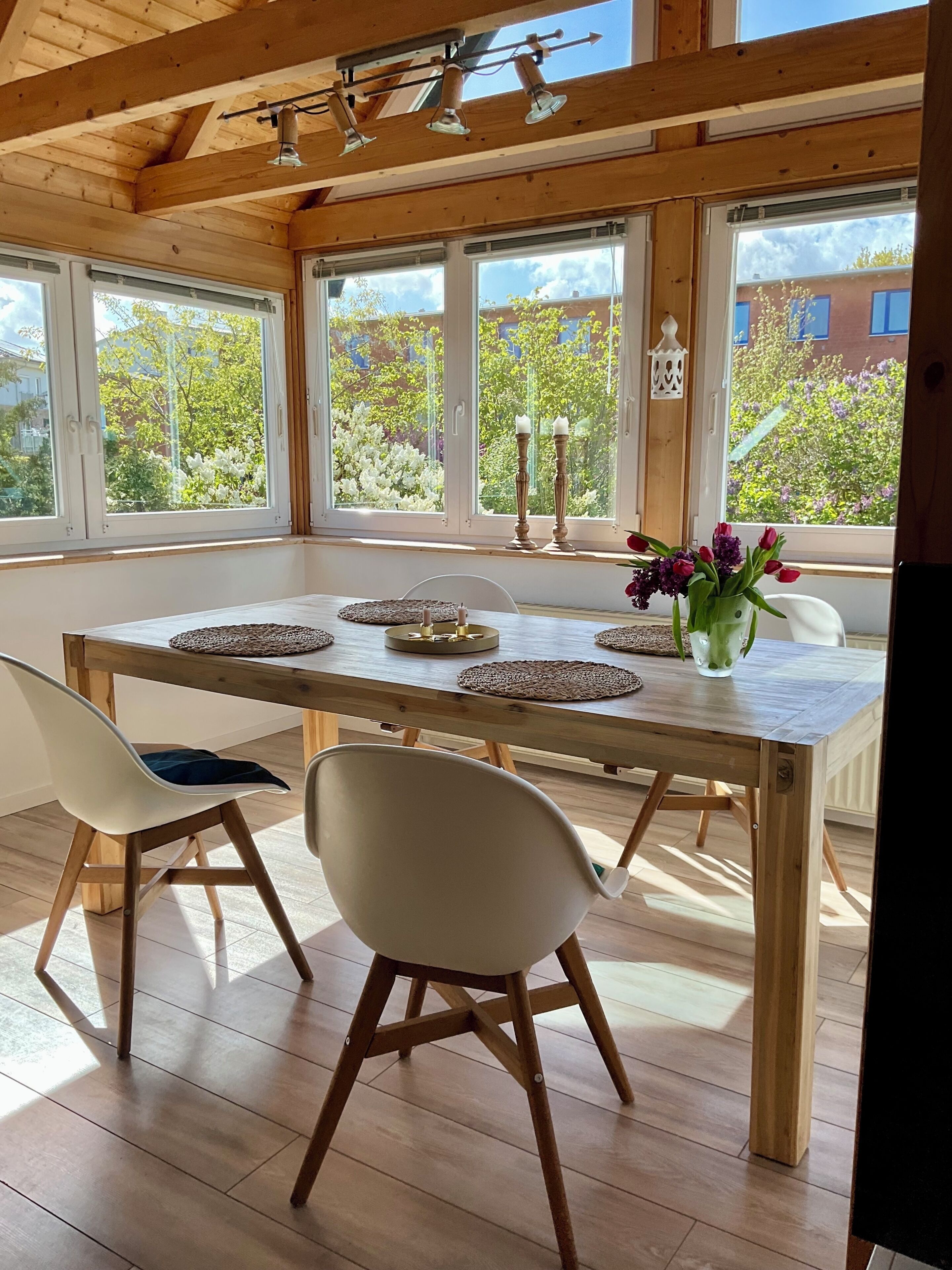Ein Essbereich mit einem Holztisch, zwei Stühlen und Blick auf Grün.