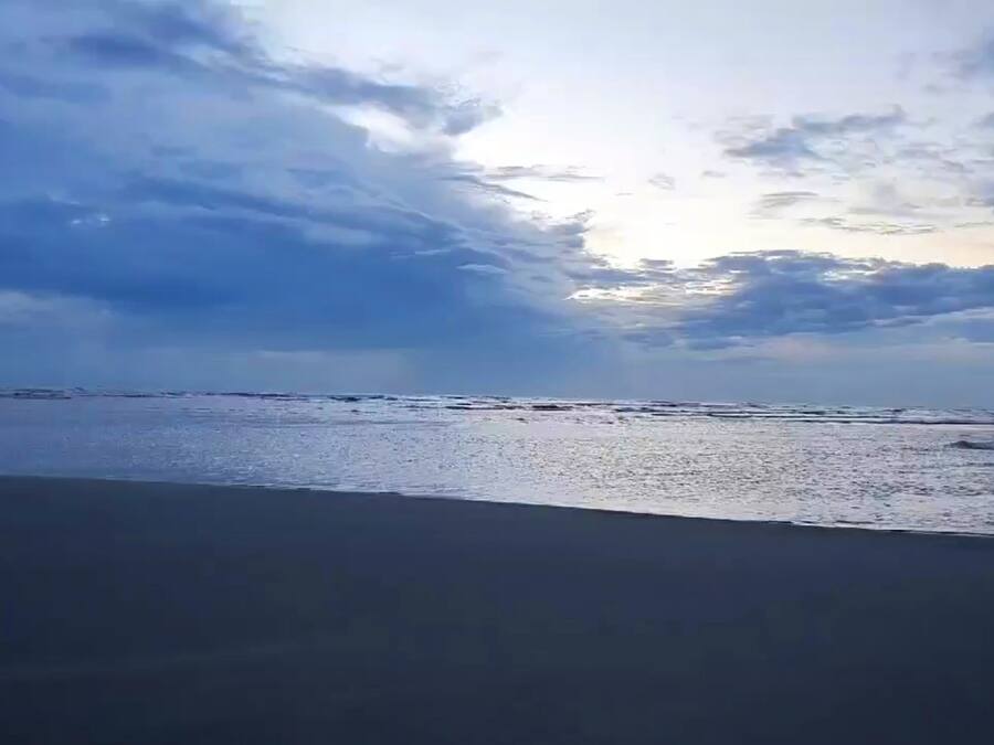 Una playa con una extensa franja de arena y un mar tranquilo.