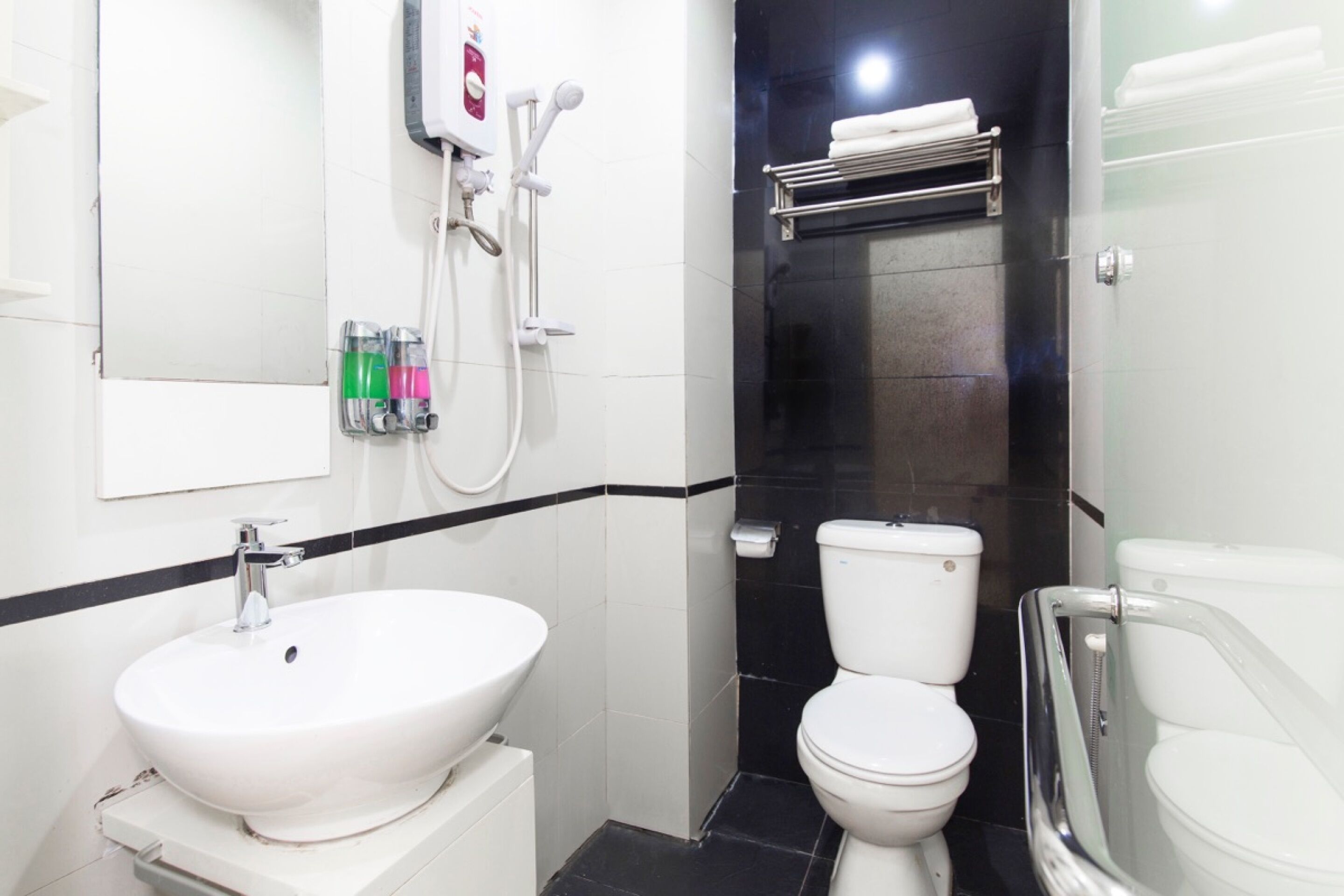 A bathroom with a white sink, a toilet, and a shower area.