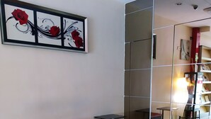 Ein moderner Wartebereich mit einer Bank, einem kleinen Tisch und einer Glastrennwand.