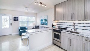 Una cocina moderna con una isla central, horno empotrado y electrodomésticos de acero inoxidable.