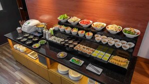A buffet with various dishes and condiments arranged on a black counter. - Azumaya Hotel Linh Lang (Hanoi)