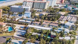 Un hotel costero con varias construcciones, piscina y vistas a la playa.