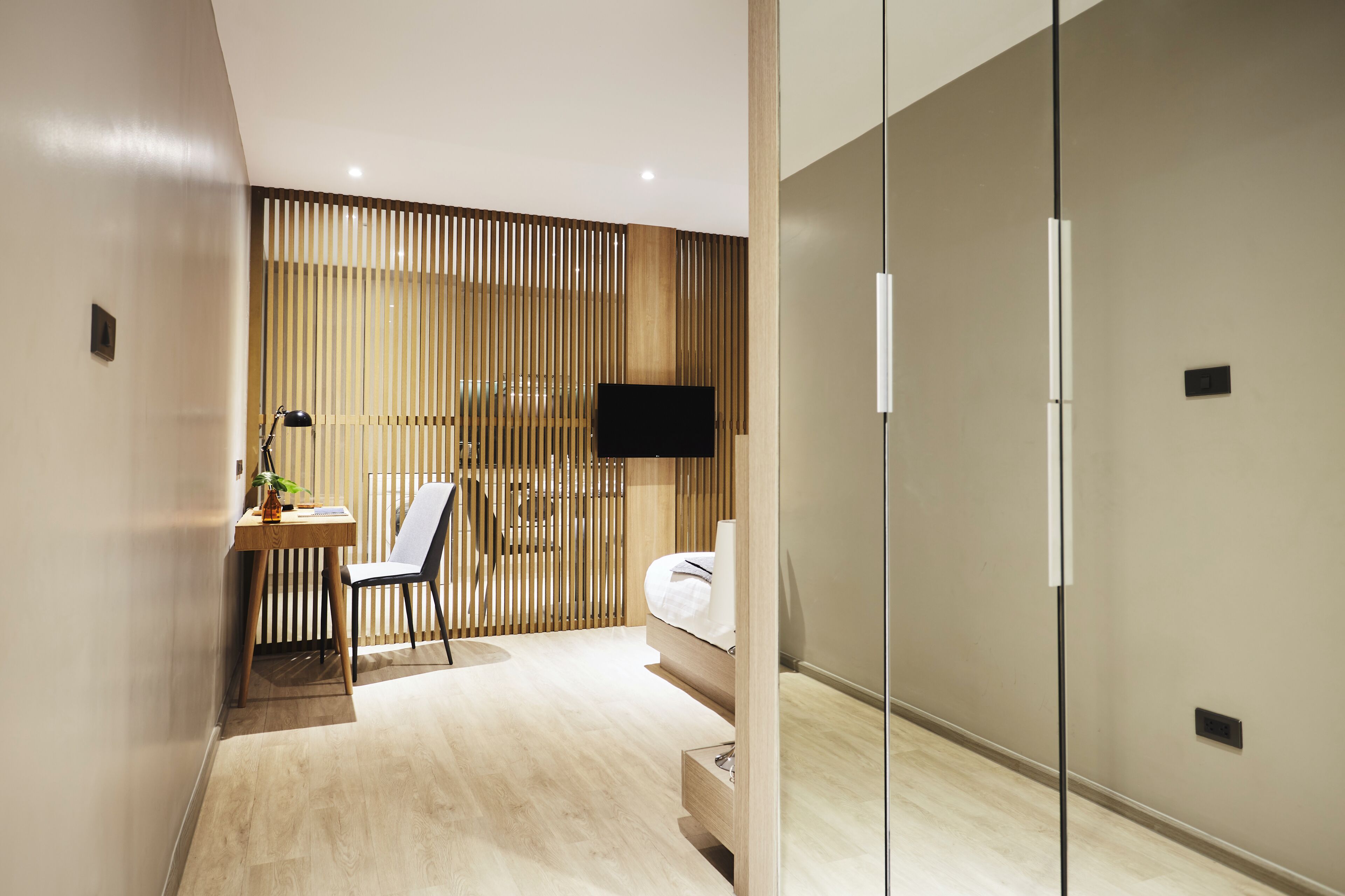 Una habitación de hotel moderna con escritorio, silla y cama.