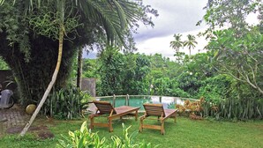 A poolside area with wooden loungers, a small pool, and lush greenery. - Meadow Villa - Galle (Galle)