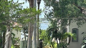 A lush garden with palm trees and a building with arched windows. - Location Anastasia Island home, Bring your bikes! (St Augustine)