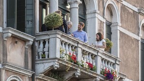 A multi-story building with a balcony featuring arched windows and columns, adorned with flowers. - Palazzo Vendramin-Costa  Artist Studio-Loft (Venice)