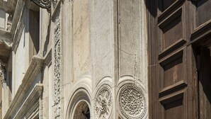 A building facade with ornate architectural details, including carved stonework and a wooden door with a decorative handle. - Palazzo Vendramin-Costa  Artist Studio-Loft (Venice)