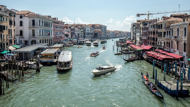 A canal with boats and gondolas, surrounded by historic buildings with balconies and red awnings. - Palazzo Vendramin-Costa  Artist Studio-Loft (Venice)
