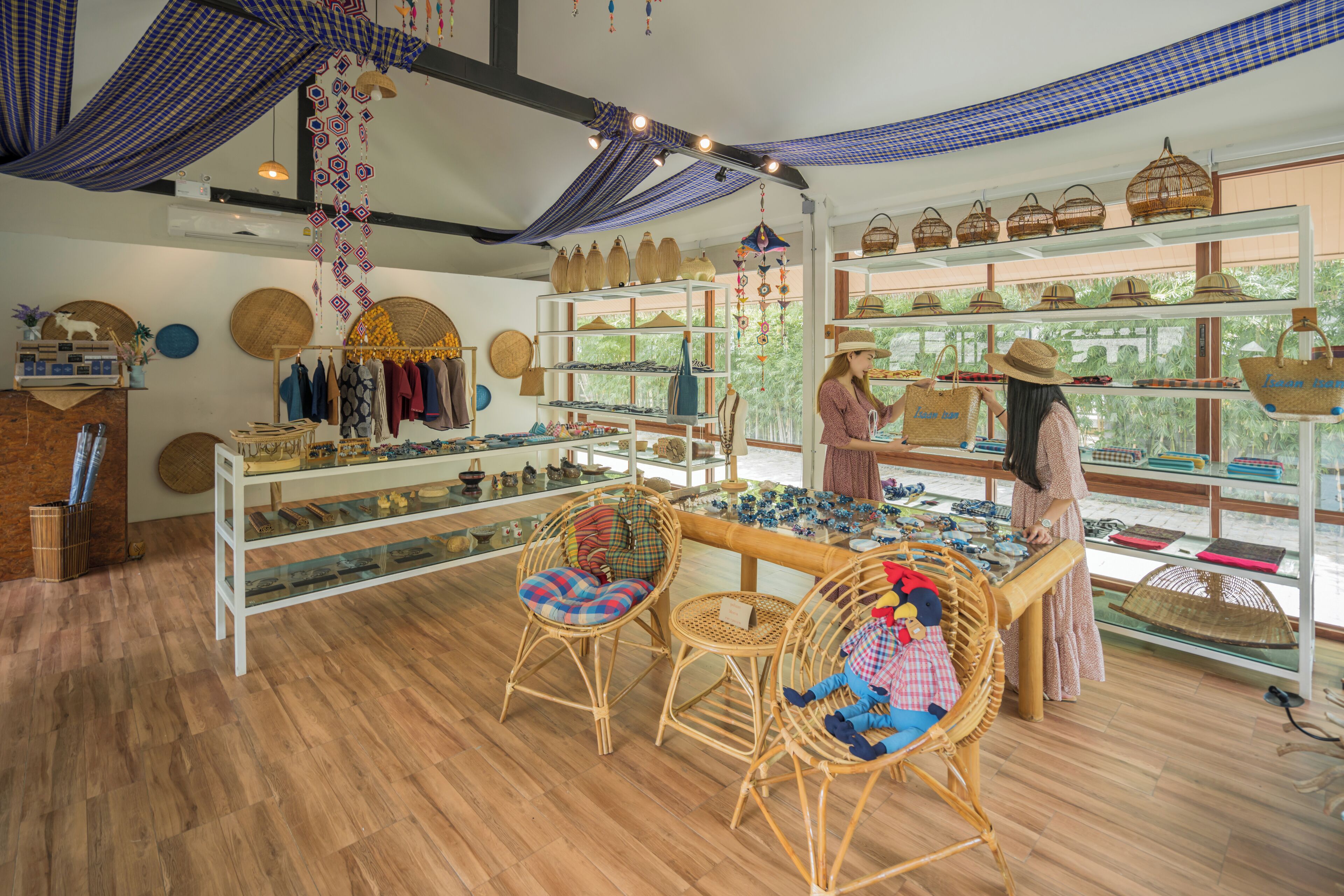 A boutique store with wicker furniture, shelves of woven baskets, and a variety of textiles.