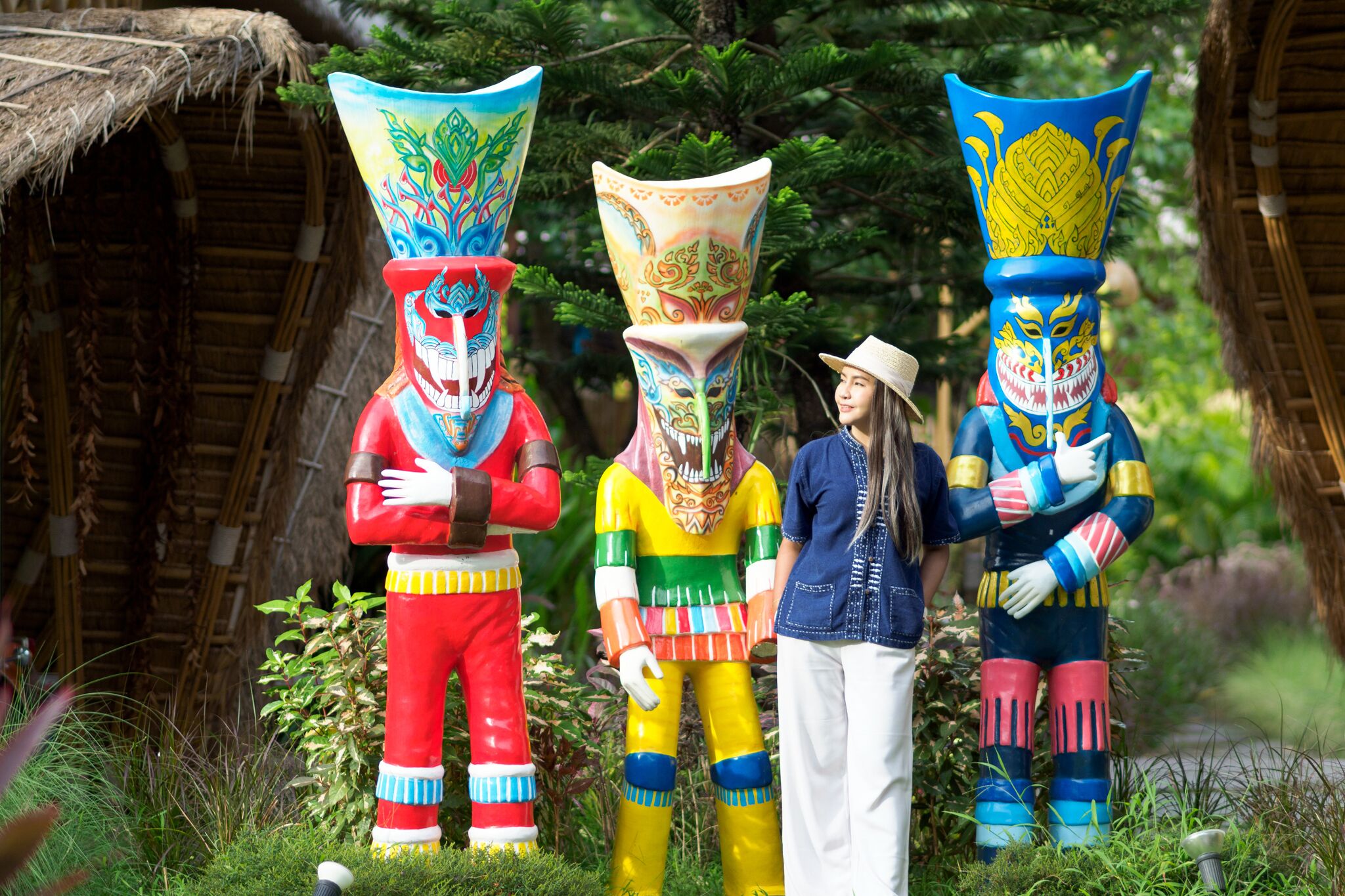 Tres estatuas coloridas en un jardín.