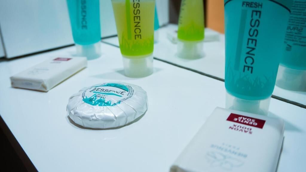 Exhibición de productos de cuidado personal, incluyendo una pastilla de jabón y botellas de Essence, jabón corporal.