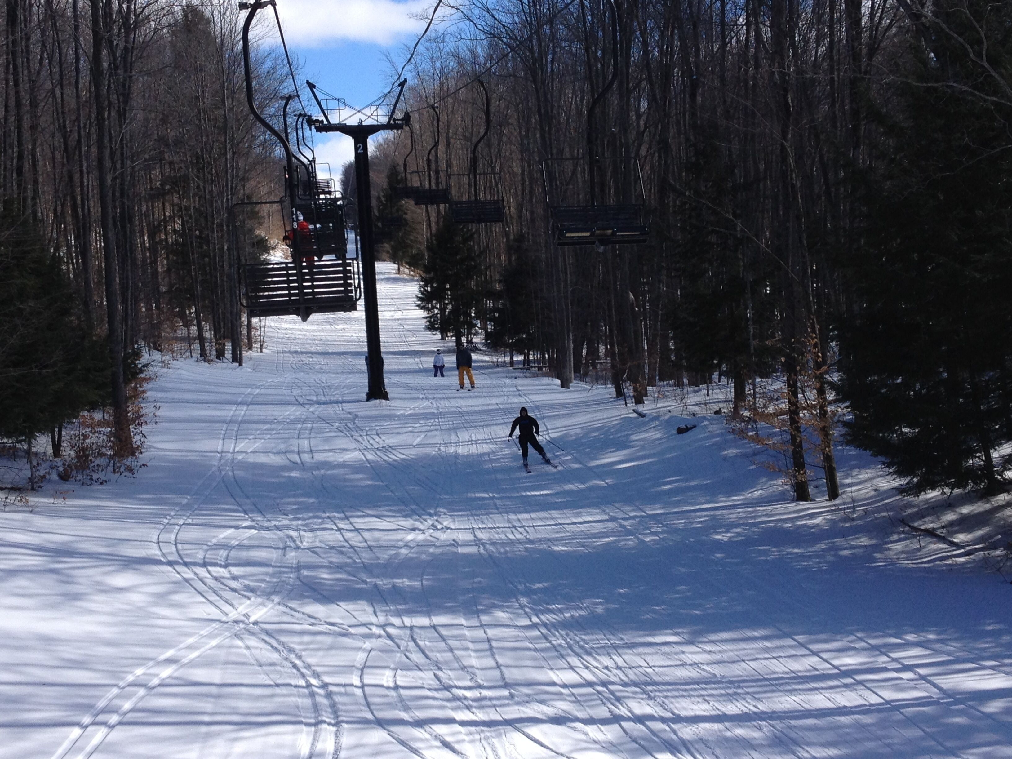 A snowy ski slope with a ski lift in the background.