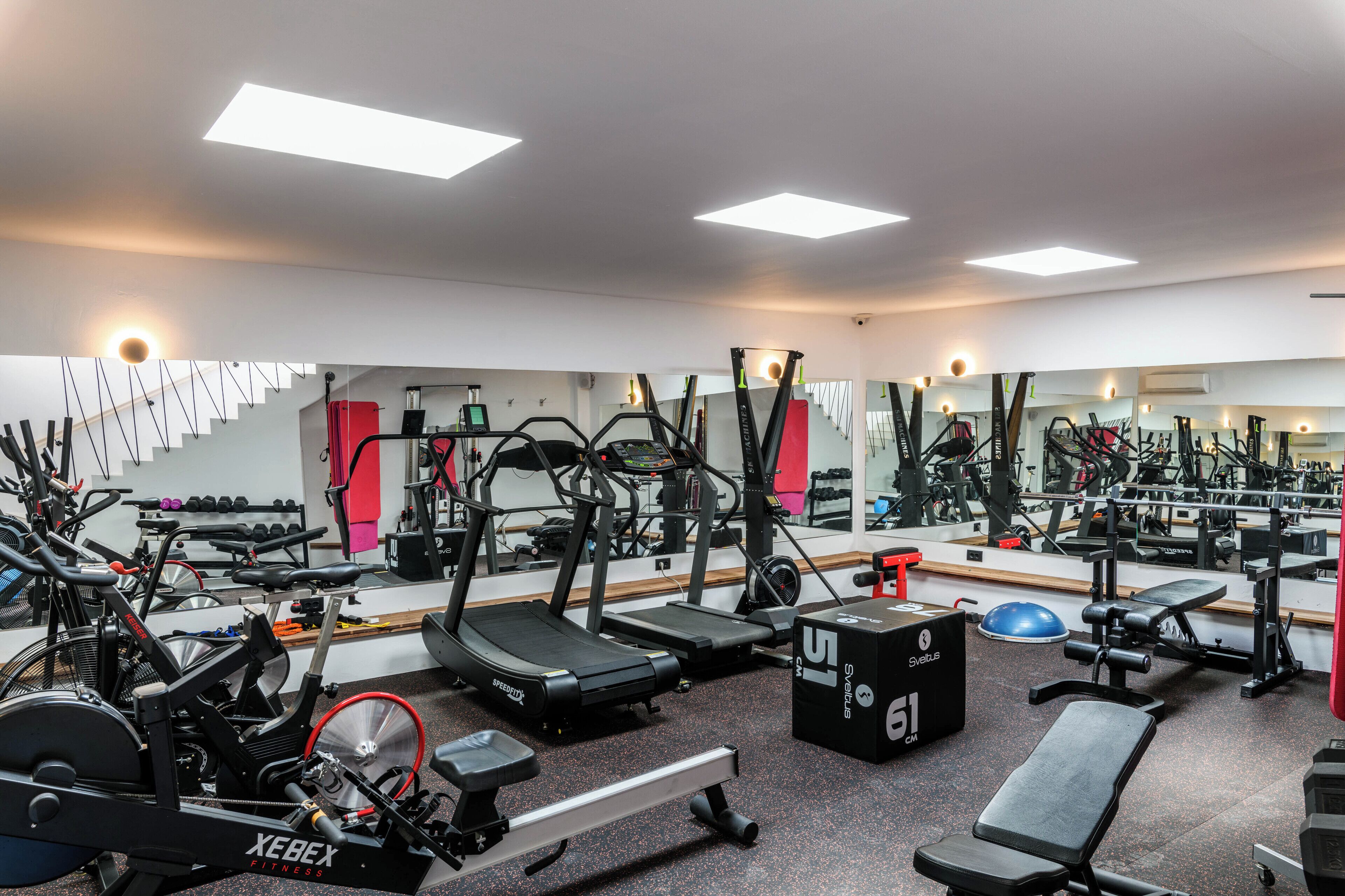 A gym with various exercise equipment, including treadmills, stationary bikes, and weight machines.