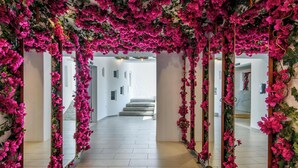 A hallway with mirrored walls and pink floral decorations. - Mykonos Drops (Mykonos)