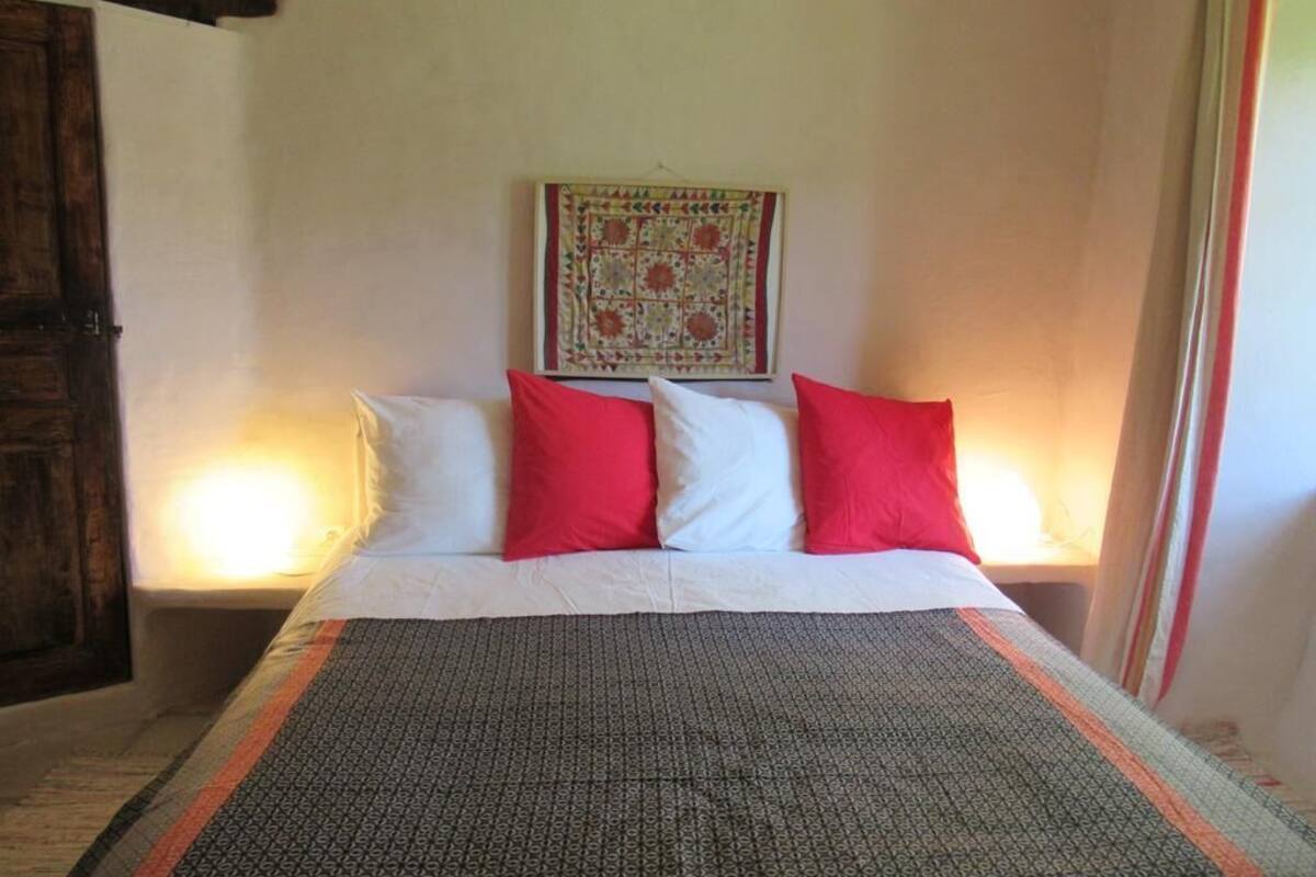 Ein Bett mit einem gemusterten Überwurf, zwei Kissen und einer gesteppten Decke.