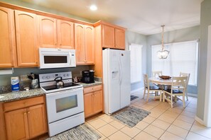 Enjoy cooking in this well-equipped kitchen with a stove, microwave, and refrigerator.