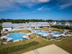 Relax by the resort's large pool surrounded by lush greenery and lounge chairs.