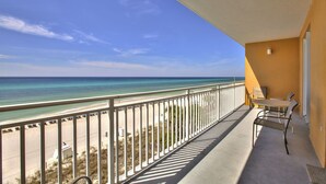 Un balcon avec vue sur la plage et l’océan.