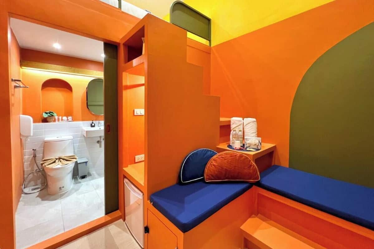 Een privéluxe kamer met een bed, een tafeltje en een spiegel.