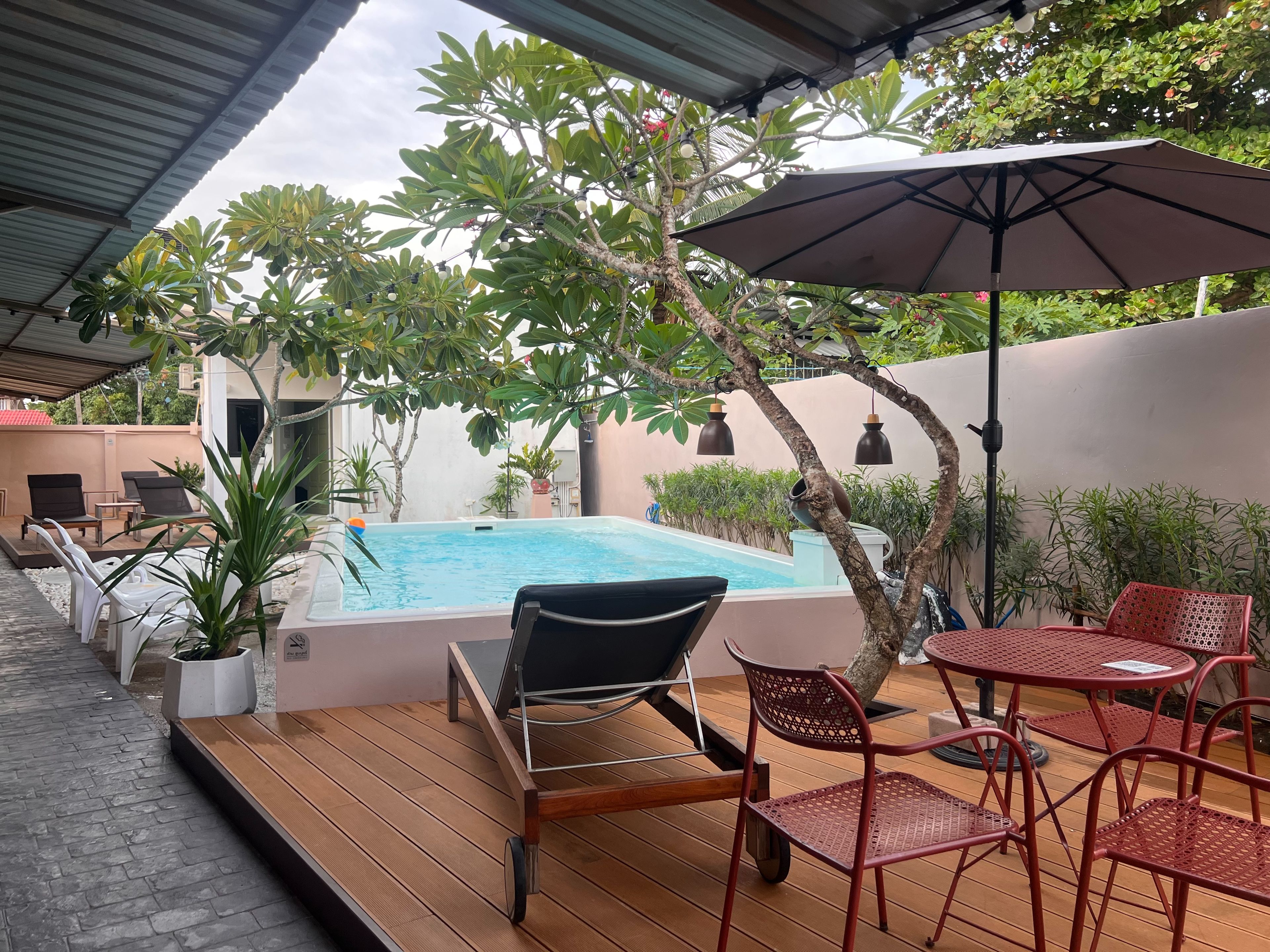 Zona exterior coberta amb piscina, seients i plantes en testos.