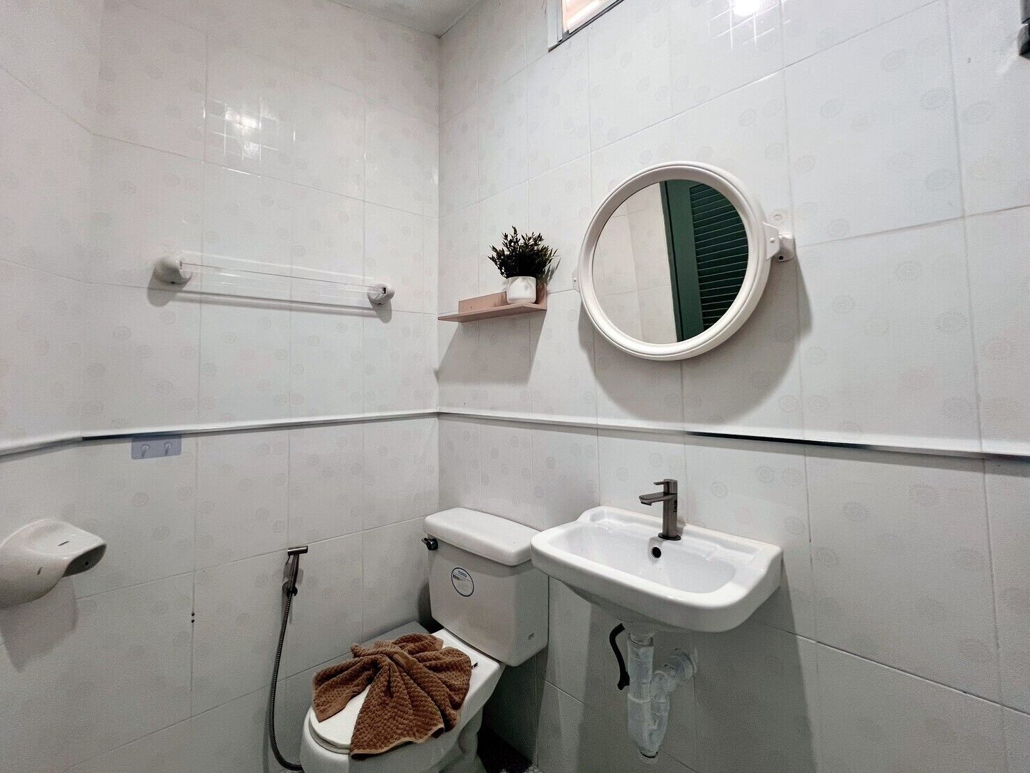 A bathroom with a toilet, sink, and a towel rack.