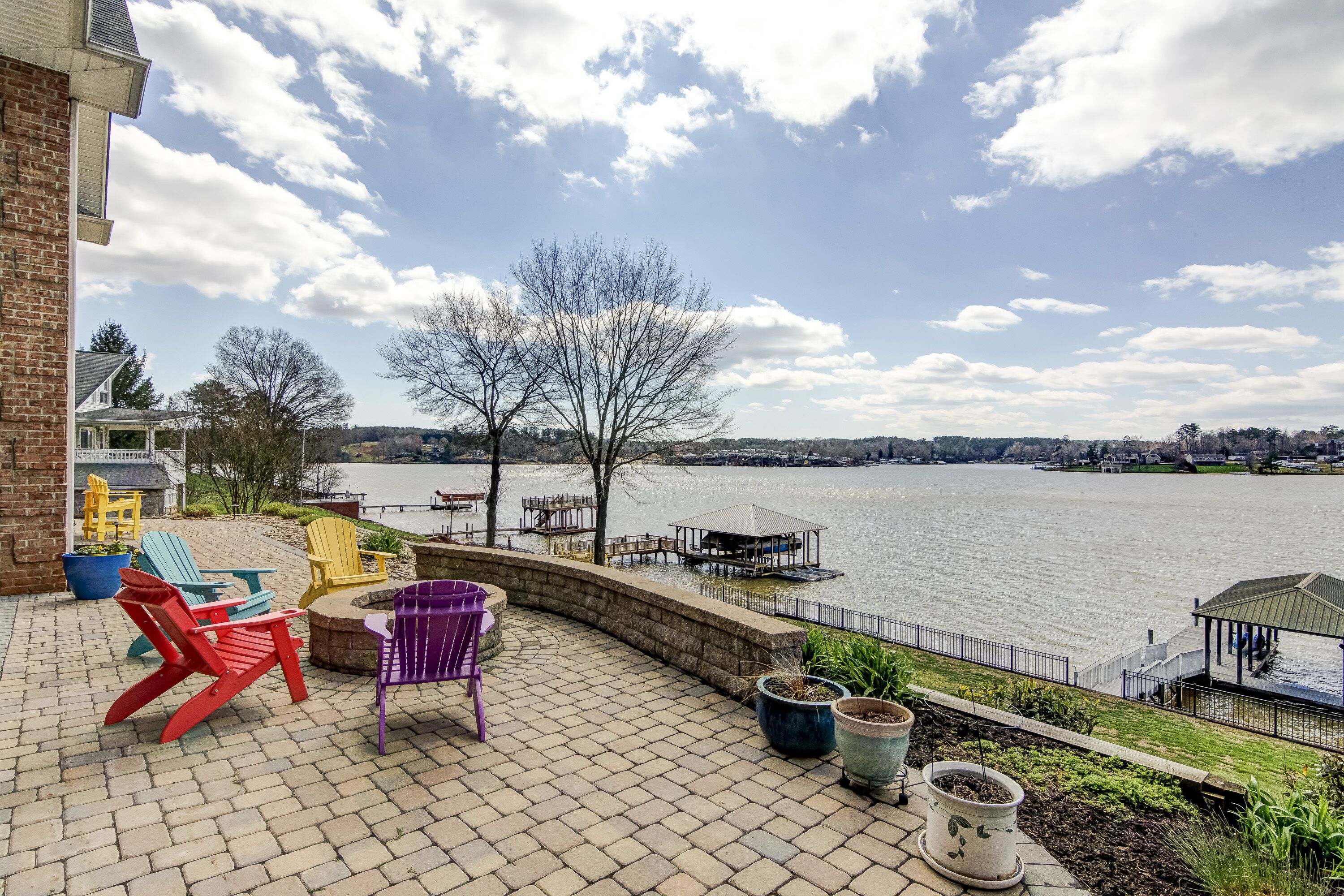 Un patio con mobiliario exterior y vista a un lago.