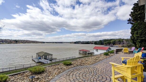 A lakeside patio with Adirondack chairs, a gazebo, and a dock. - #1 Rated Vacation Home w/ Deep Water on the Main Channel (Taylorsville)