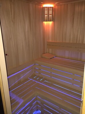 Uma sauna com paredes de madeira e um banco.
