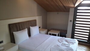 A bedroom with a bed, bedside tables, and a window with blinds. - Leader Mansion Hotel & Suite (Istanbul)