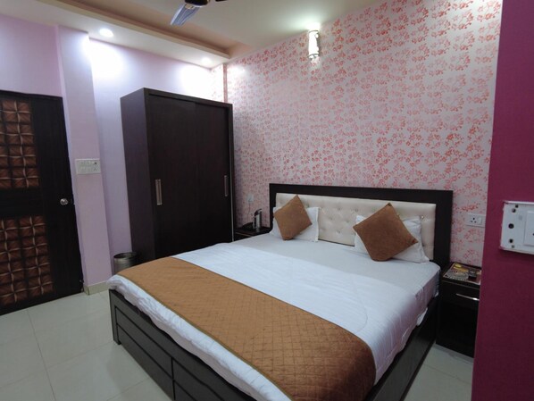 A bedroom with a bed, wardrobe, and a nightstand.