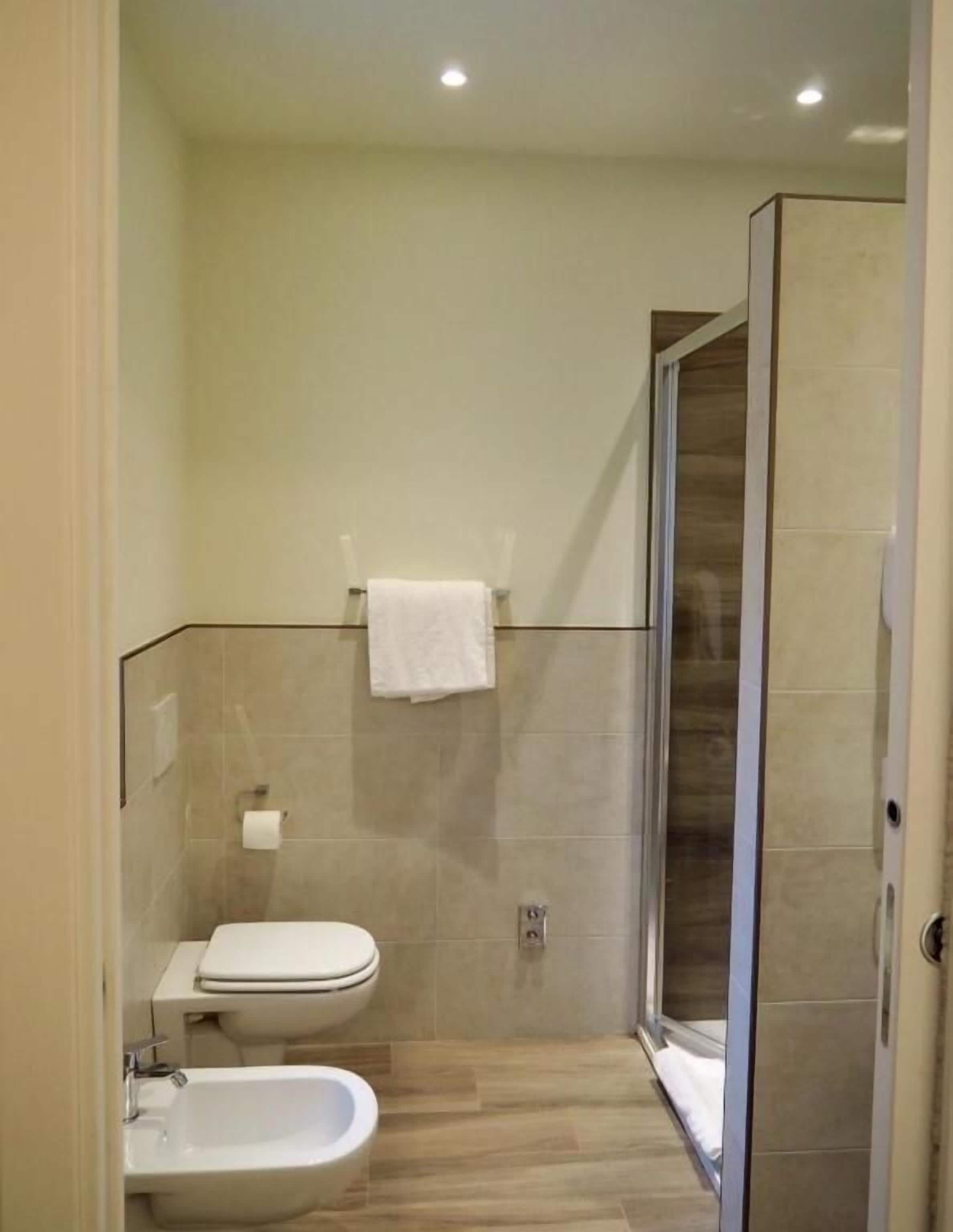 A modern bathroom with a toilet, bidet, and shower area.
