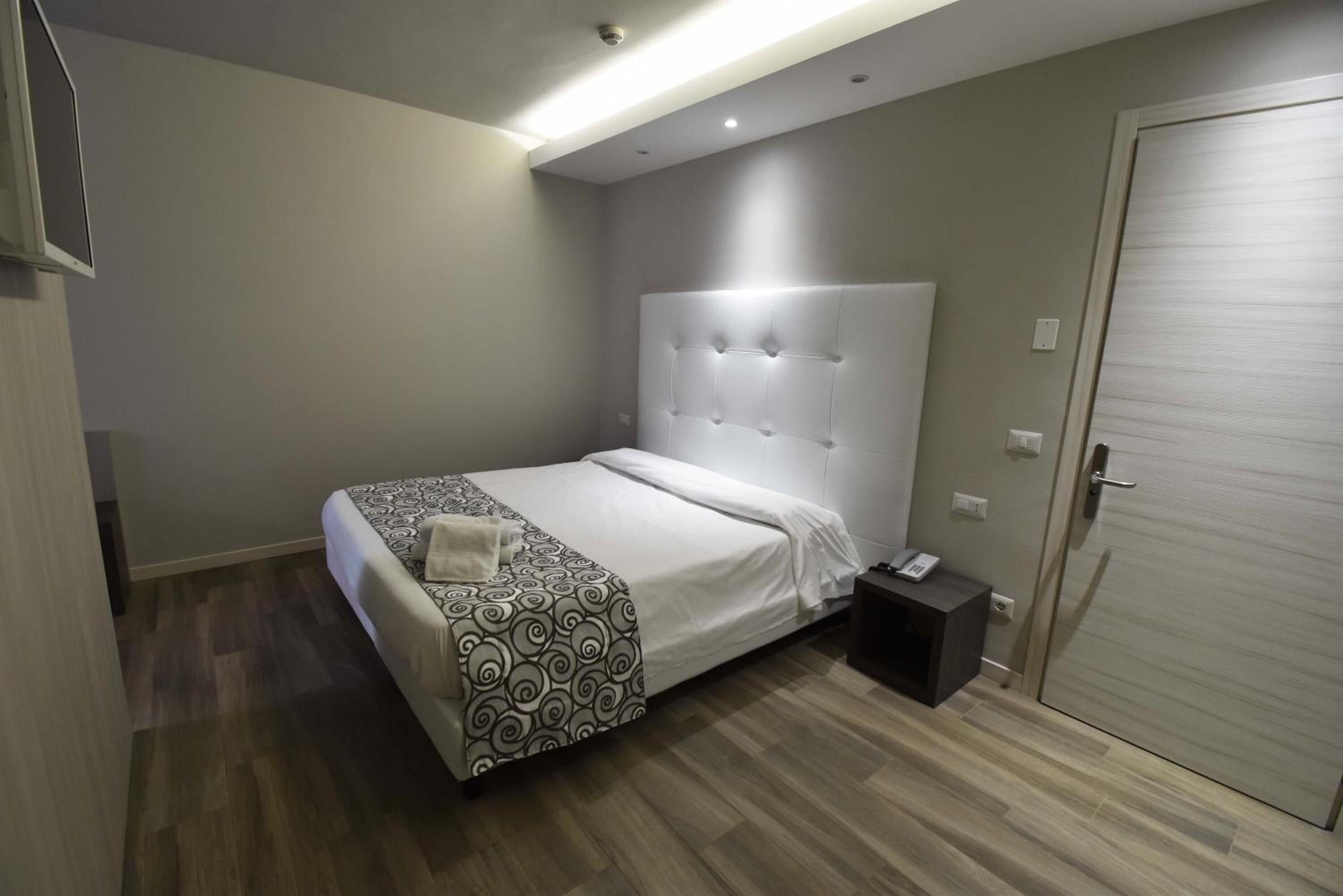 Ein modernes Schlafzimmer mit einem großen Bett, einem Nachttisch und einem Kleiderschrank.