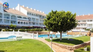 A hotel with a swimming pool, a well-maintained lawn, and a large tree. - Al-andalus Casa Azahar (Alcala de Xivert)